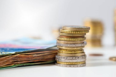 Avro paraları yığılmış ve banknotlar beyaz masanın üzerinde duruyor.