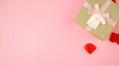 Pembe arka planın köşesinde yatıyor.