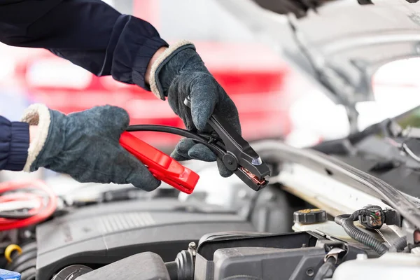 Humano tentando ligar o motor com cabos jumper de perto — Fotografia de Stock