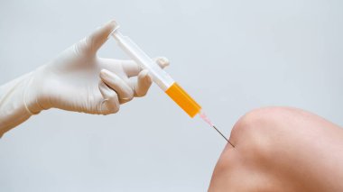 Doktor, dizinde trombosit zengini plazma enjeksiyonuyla kök hücre tedavisi yapıyor..