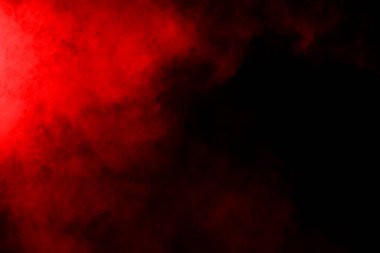 Siyah arka planda soyut kırmızı toz patlaması. Siyah arka planda soyut kırmızı toz sıçramış. Patlayan kırmızı barutun hareketsiz hareketi.