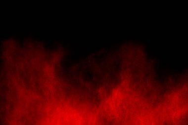 Siyah arka planda soyut kırmızı toz patlaması. Siyah arka planda soyut kırmızı toz sıçramış. Patlayan kırmızı barutun hareketsiz hareketi.