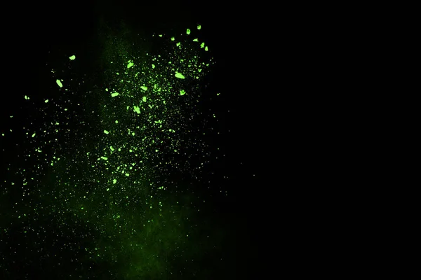The movement of abstract dust explosion frozen green on black background. Stop the movement of powdered green on black background. Explosive powder green on black background.