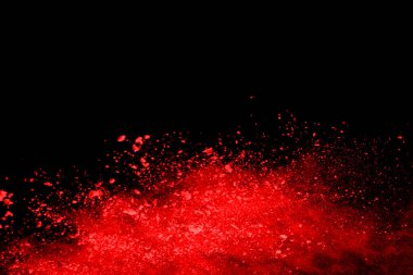 Siyah arka planda soyut kırmızı toz patlaması. Siyah arka planda soyut kırmızı toz sıçramış. Patlayan kırmızı barutun hareketsiz hareketi.