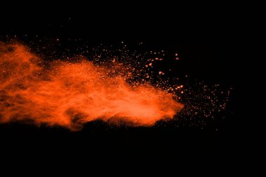 Patlayan turuncu barutun dondurucu hareketi siyah arka planda izole edilmiş. Kırmızı toz bulutunun soyut tasarımı.