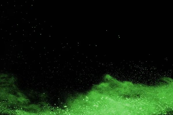 The movement of abstract dust explosion frozen green on black background. Stop the movement of powdered green on black background. Explosive powder green on black background.