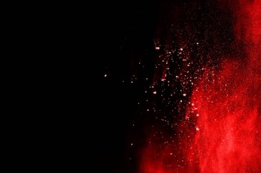 Patlayan turuncu barutun dondurucu hareketi siyah arka planda izole edilmiş. Kırmızı toz bulutunun soyut tasarımı.