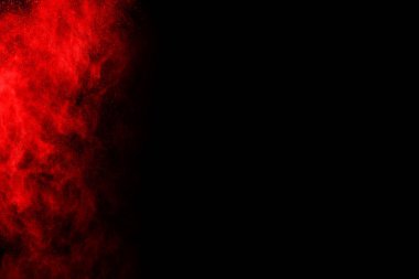 Siyah arka planda soyut kırmızı toz patlaması. Siyah arka planda soyut kırmızı toz sıçramış. Patlayan kırmızı barutun hareketsiz hareketi.