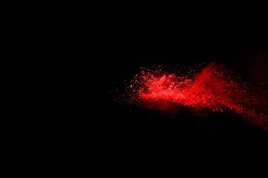 Siyah arka planda soyut kırmızı toz patlaması. Siyah arka planda soyut kırmızı toz sıçramış. Patlayan kırmızı barutun hareketsiz hareketi.