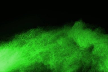 Soyut toz patlamasının hareketi siyah arka planda donmuş yeşil. Siyah zemin üzerindeki toz yeşilinin hareketini durdur. Patlayıcı tozu siyah arkaplanda yeşil.