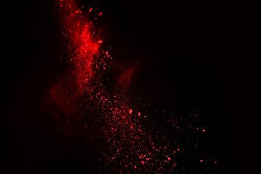 Siyah arka planda soyut kırmızı toz patlaması. Siyah arka planda soyut kırmızı toz sıçramış. Patlayan kırmızı barutun hareketsiz hareketi.
