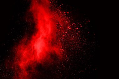 Siyah arka planda soyut kırmızı toz patlaması. Siyah arka planda soyut kırmızı toz sıçramış. Patlayan kırmızı barutun hareketsiz hareketi.