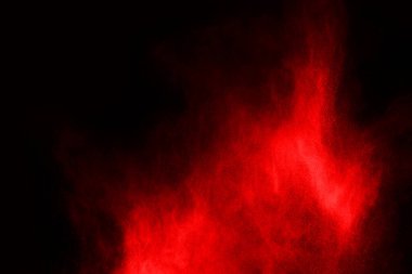 Siyah arka planda soyut kırmızı toz patlaması. Siyah arka planda soyut kırmızı toz sıçramış. Patlayan kırmızı barutun hareketsiz hareketi.