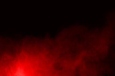 Siyah arka planda soyut kırmızı toz patlaması. Siyah arka planda soyut kırmızı toz sıçramış. Patlayan kırmızı barutun hareketsiz hareketi.