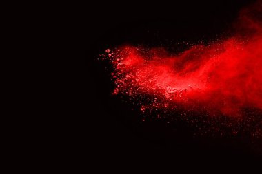 Siyah arka planda soyut kırmızı toz patlaması. Siyah arka planda soyut kırmızı toz sıçramış. Patlayan kırmızı barutun hareketsiz hareketi.