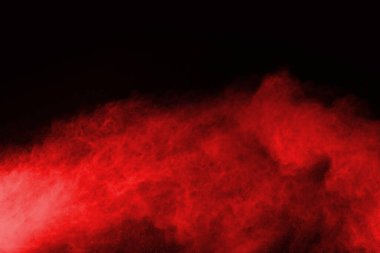 Siyah arka planda soyut kırmızı toz patlaması. Siyah arka planda soyut kırmızı toz sıçramış. Patlayan kırmızı barutun hareketsiz hareketi.