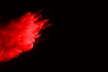 Siyah arka planda soyut kırmızı toz patlaması. Siyah arka planda soyut kırmızı toz sıçramış. Patlayan kırmızı barutun hareketsiz hareketi.