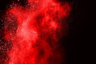 Siyah arka planda soyut kırmızı toz patlaması. Siyah arka planda soyut kırmızı toz sıçramış. Patlayan kırmızı barutun hareketsiz hareketi.
