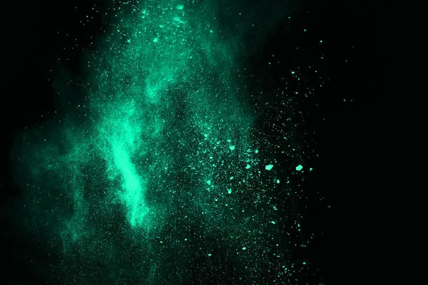 The movement of abstract dust explosion frozen green on black background. Stop the movement of powdered green on black background. Explosive powder green on black background.