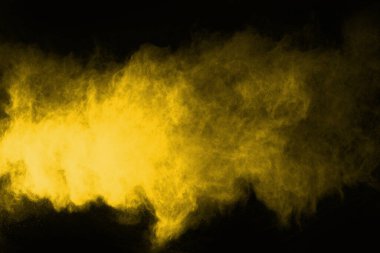 Siyah arka planda sarı toz patlaması. Renkli bulut. Renkli toz patlar. Boya Holi.