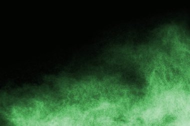 Soyut toz patlamasının hareketi siyah arka planda donmuş yeşil. Siyah zemin üzerindeki toz yeşilinin hareketini durdur. Patlayıcı tozu siyah arkaplanda yeşil.