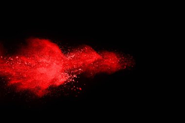 Siyah arka planda soyut kırmızı toz patlaması. Siyah arka planda soyut kırmızı toz sıçramış. Patlayan kırmızı barutun hareketsiz hareketi.