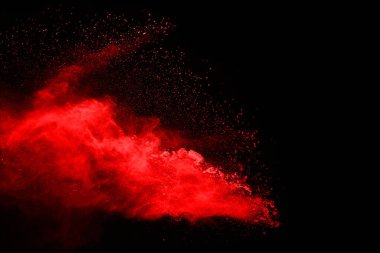 Siyah arka planda soyut kırmızı toz patlaması. Siyah arka planda soyut kırmızı toz sıçramış. Patlayan kırmızı barutun hareketsiz hareketi.