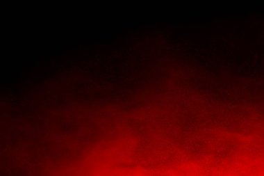 Siyah arka planda soyut kırmızı toz patlaması. Siyah arka planda soyut kırmızı toz sıçramış. Patlayan kırmızı barutun hareketsiz hareketi.