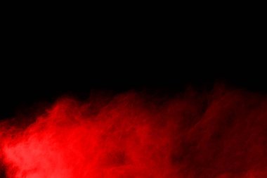 Siyah arka planda soyut kırmızı toz patlaması. Siyah arka planda soyut kırmızı toz sıçramış. Patlayan kırmızı barutun hareketsiz hareketi.