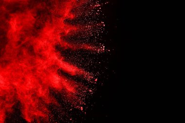 Siyah arka planda soyut kırmızı toz patlaması. Siyah arka planda soyut kırmızı toz sıçramış. Patlayan kırmızı barutun hareketsiz hareketi.