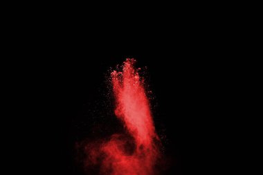 Siyah arka planda soyut kırmızı toz patlaması. Siyah arka planda soyut kırmızı toz sıçramış. Patlayan kırmızı barutun hareketsiz hareketi.