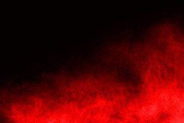 Siyah arka planda soyut kırmızı toz patlaması. Siyah arka planda soyut kırmızı toz sıçramış. Patlayan kırmızı barutun hareketsiz hareketi.