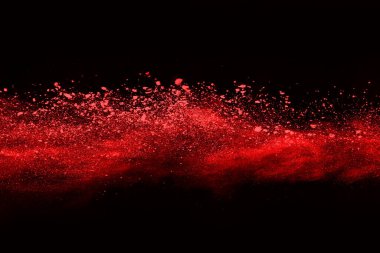 Siyah arka planda soyut kırmızı toz patlaması. Siyah arka planda soyut kırmızı toz sıçramış. Patlayan kırmızı barutun hareketsiz hareketi.