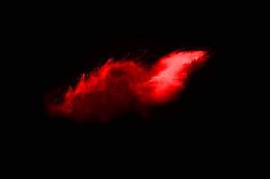 Siyah arka planda soyut kırmızı toz patlaması. Siyah arka planda soyut kırmızı toz sıçramış. Patlayan kırmızı barutun hareketsiz hareketi.