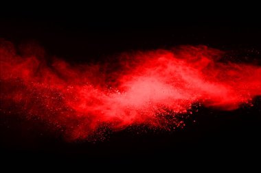 Siyah arka planda soyut kırmızı toz patlaması. Siyah arka planda soyut kırmızı toz sıçramış. Patlayan kırmızı barutun hareketsiz hareketi.