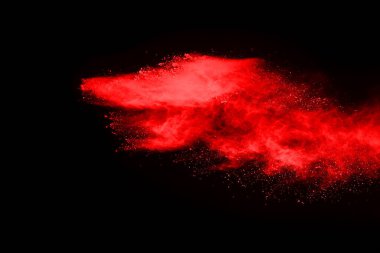 Siyah arka planda soyut kırmızı toz patlaması. Siyah arka planda soyut kırmızı toz sıçramış. Patlayan kırmızı barutun hareketsiz hareketi.