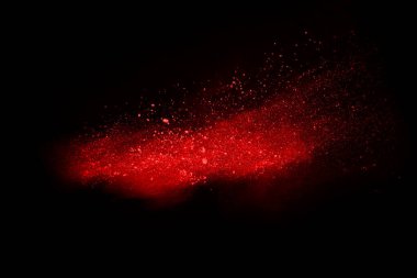 Siyah arka planda soyut kırmızı toz patlaması. Siyah arka planda soyut kırmızı toz sıçramış. Patlayan kırmızı barutun hareketsiz hareketi.