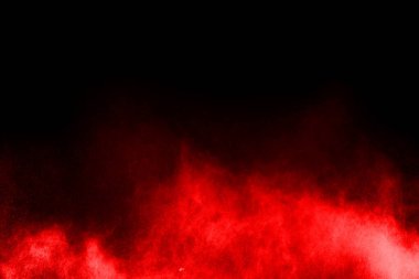 Siyah arka planda soyut kırmızı toz patlaması. Siyah arka planda soyut kırmızı toz sıçramış. Patlayan kırmızı barutun hareketsiz hareketi.