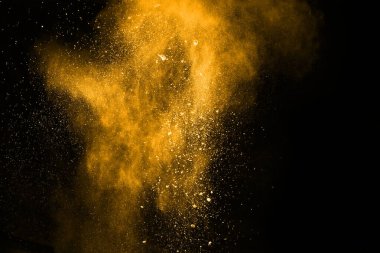 Soyut turuncu toz sıçramış arka plan, patlayan renk tozunun dondurucu hareketi / renk pudrası, siyah arkaplan üzerindeki renk parlatıcısı dokusu