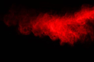 Siyah arka planda soyut kırmızı toz patlaması. Siyah arka planda soyut kırmızı toz sıçramış. Patlayan kırmızı barutun hareketsiz hareketi.