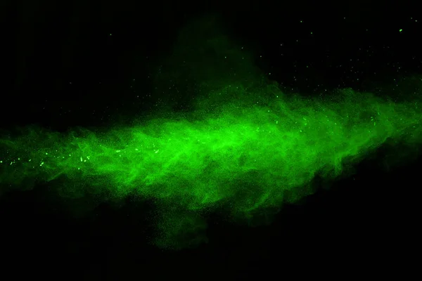 The movement of abstract dust explosion frozen green on black background. Stop the movement of powdered green on black background. Explosive powder green on black background.