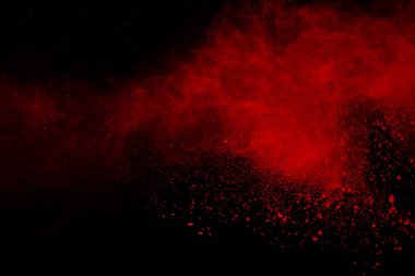 Siyah arka planda soyut kırmızı toz patlaması. Siyah arka planda soyut kırmızı toz sıçramış. Patlayan kırmızı barutun hareketsiz hareketi.