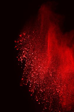 Siyah arka planda soyut kırmızı toz patlaması. Siyah arka planda soyut kırmızı toz sıçramış. Patlayan kırmızı barutun hareketsiz hareketi.