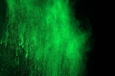 Soyut toz patlamasının hareketi siyah arka planda donmuş yeşil. Siyah zemin üzerindeki toz yeşilinin hareketini durdur. Patlayıcı tozu siyah arkaplanda yeşil.