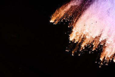 Siyah bir zemin üzerinde soyut renkli toz patlaması. Soyut toz püskürtülmüş arka plan, renk tozunun patlaması / renk tozunun dondurucu hareketi, çok renkli sim dokusu.