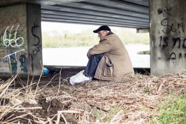 Köprünün altında oturan avare.