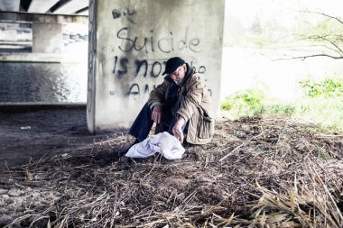 Köprünün altında oturan avare.