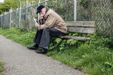 Üst düzey evsiz adam bankta  