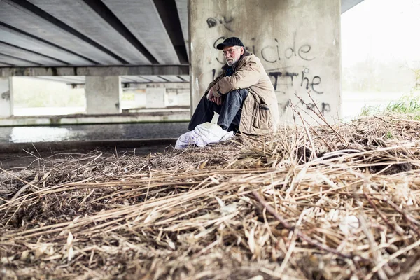 Wanderer sitting under bridge. — Stock Photo, Image