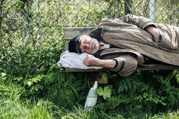 Homeless man sleeping on bench — Stock Photo, Image